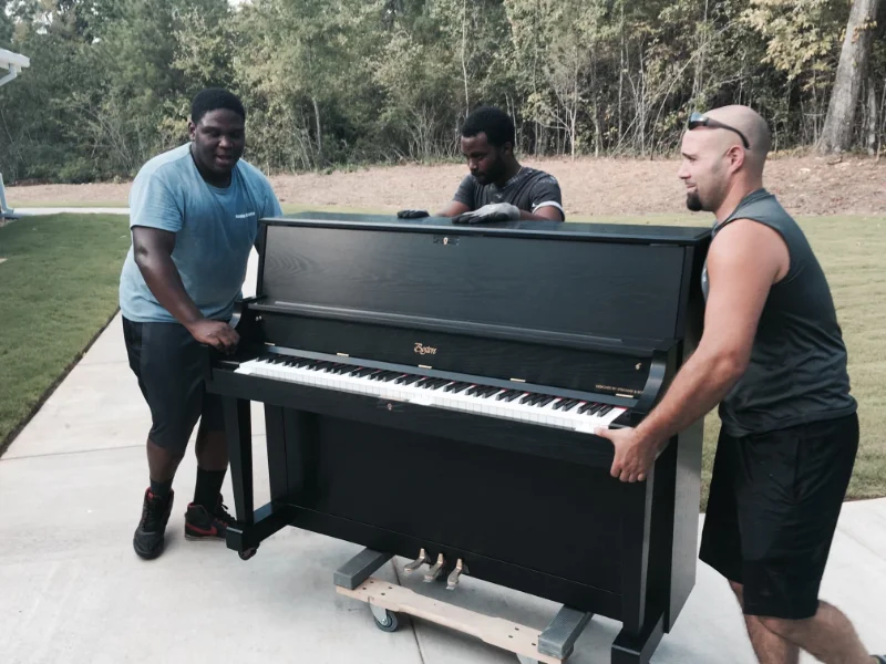 Men moving a black piano