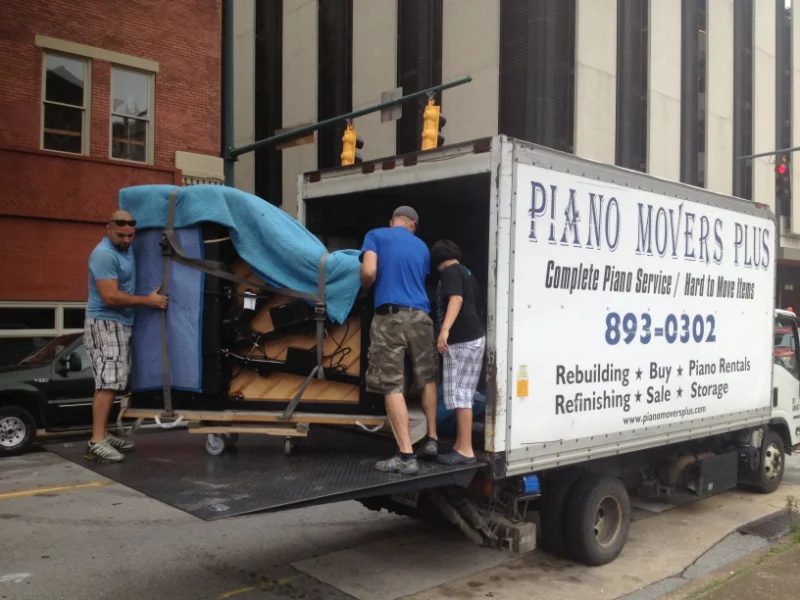 People Moving a large covered object out of a truck