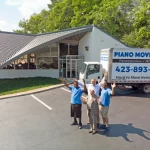 People Waving Next to Piano Movers Plus Van