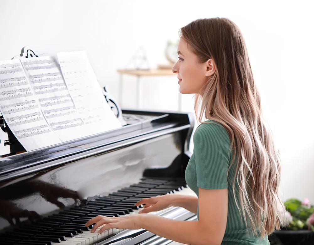 woman in green shirt playing piano